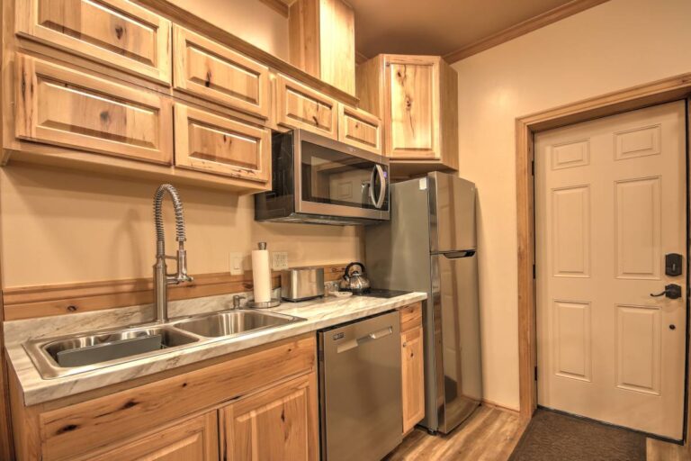 A bright kitchen scene with a sink, refrigerator, and microwave, highlighting essential appliances for daily use