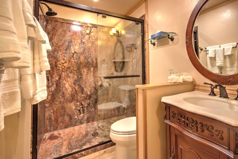 A clean bathroom featuring a shower, toilet, and sink, designed for functionality and comfort